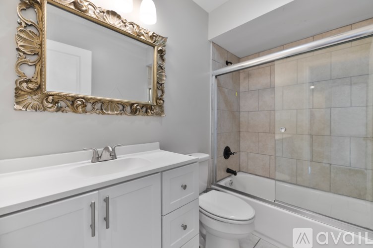 A bathroom with a white sink, toilet, and a mirror.