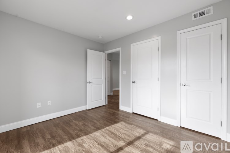 A room with white walls and a brown rug on the floor.