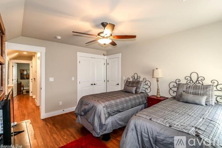 A bedroom with two beds and a ceiling fan.