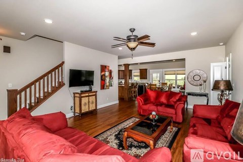 A living room with red couches and a wooden floor.