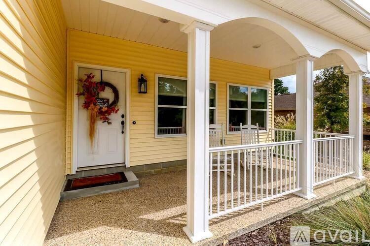 A yellow house with a white door and a wreath on it.