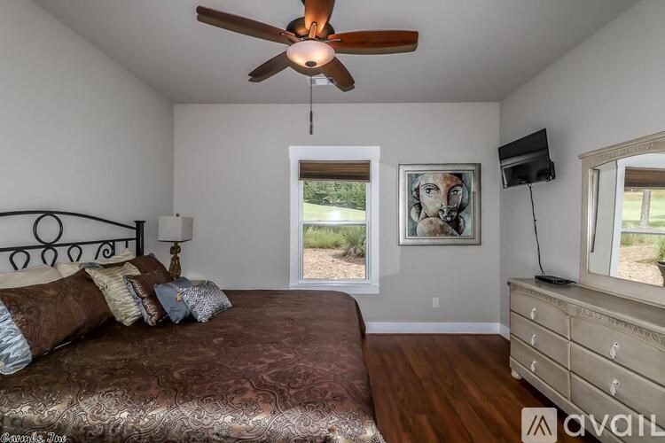 A bedroom with a bed, dresser, and a ceiling fan.