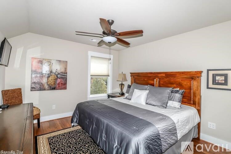 A bedroom with a large bed and a ceiling fan.