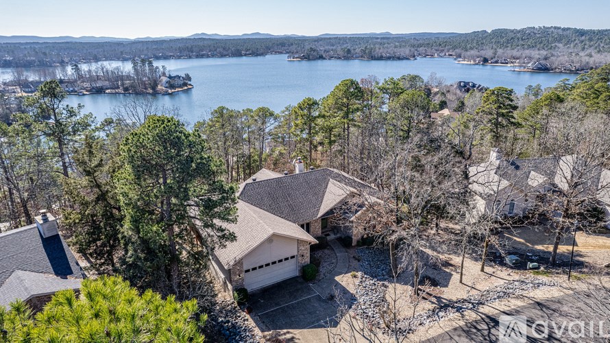 A house with a boat in the water in the distance.