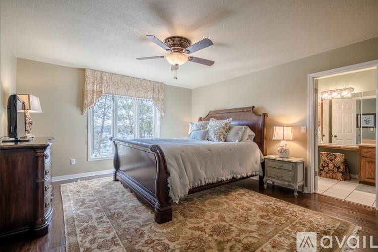 A bedroom with a large bed and a ceiling fan.