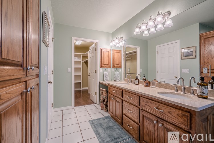 A bathroom with wooden cabinets and a white sink.