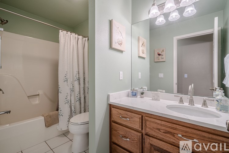 A bathroom with a white tub, sink, and toilet.