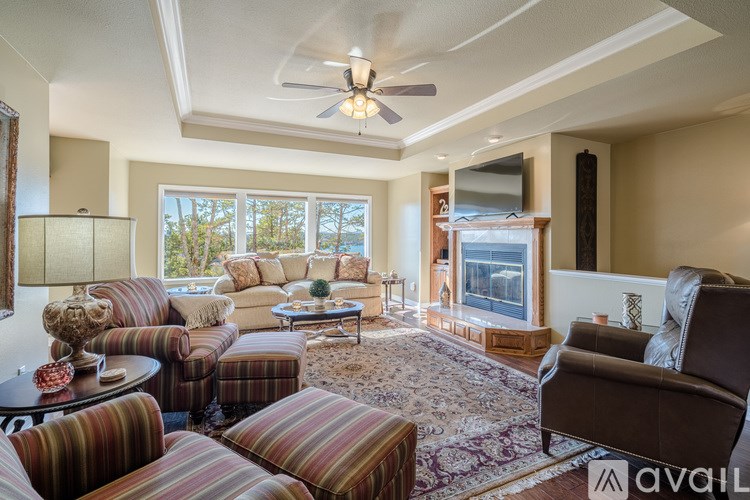 A living room with a striped couch and a ceiling fan.