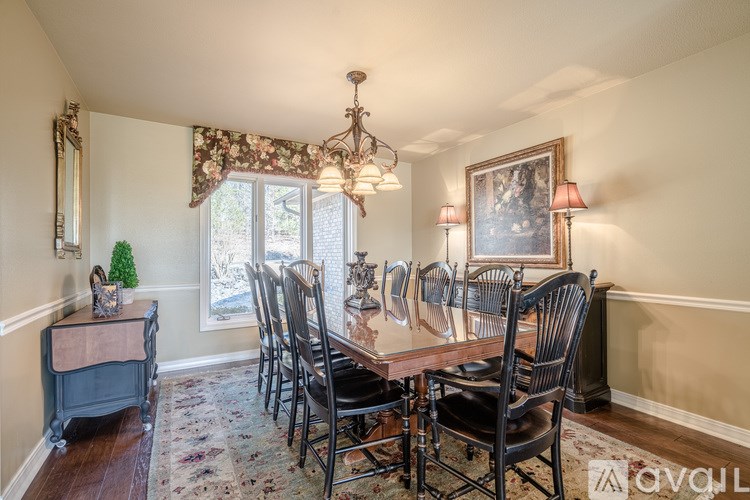 A dining room with a wooden table and chairs.