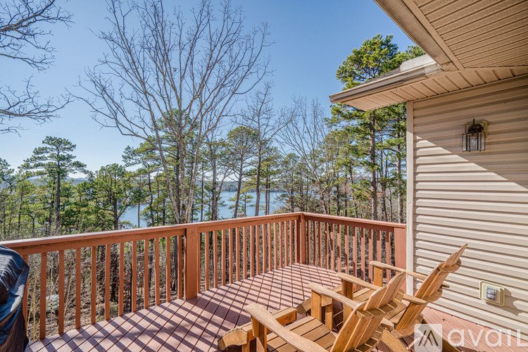 A deck with a table and chairs overlooking a forest.