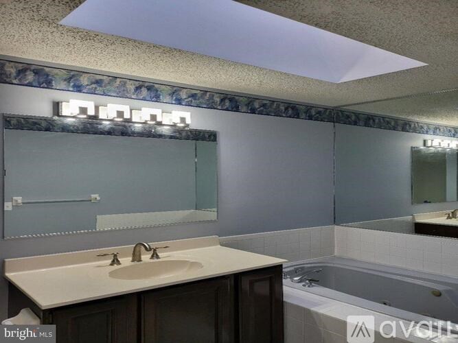 A bathroom with a skylight above the sink.