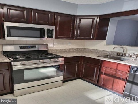 A kitchen with brown cabinets and a stainless steel oven.