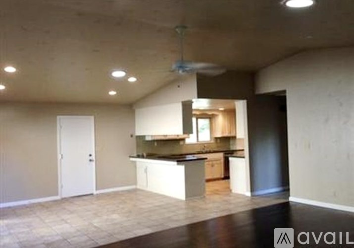 A spacious kitchen with a fan on the ceiling.