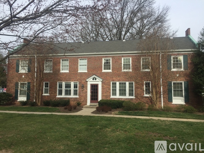 A brick house with a green lawn in front.