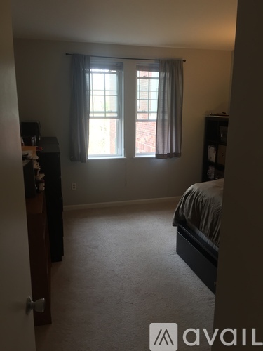 A bedroom with a bed, dresser, and window.