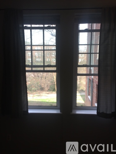 A window with a view of a building and trees.