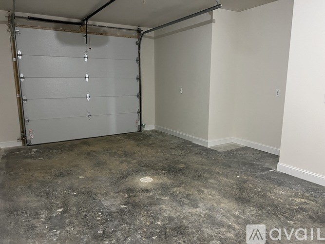 A room with a white wall and a white door with a metal frame.