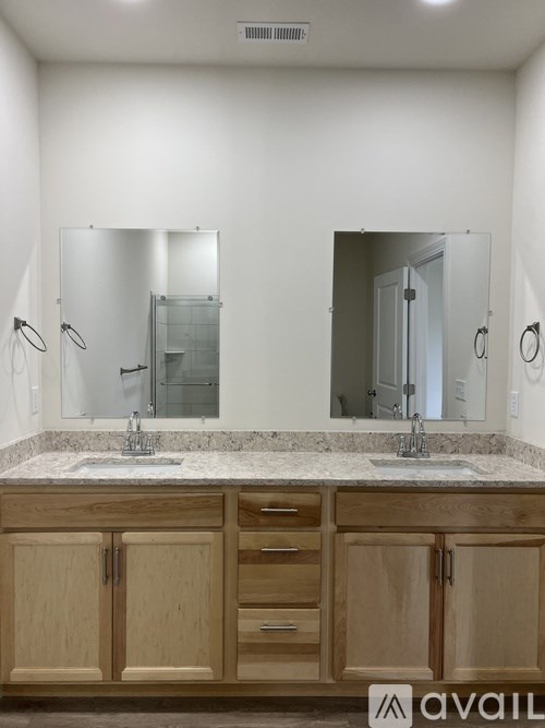 A bathroom with two sinks and a large mirror.