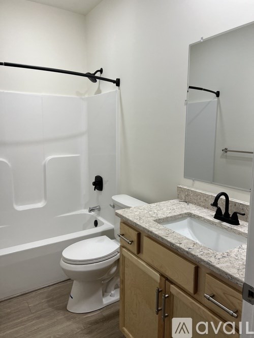 A white toilet sits in a bathroom next to a sink.