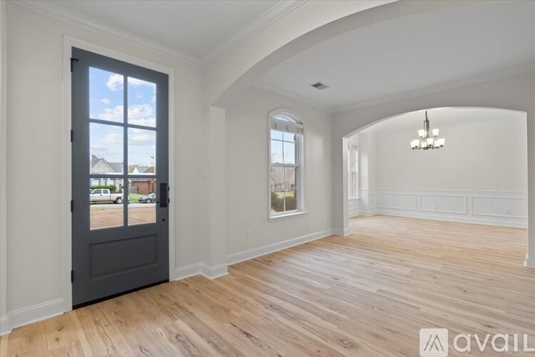 A room with a large door and a chandelier.