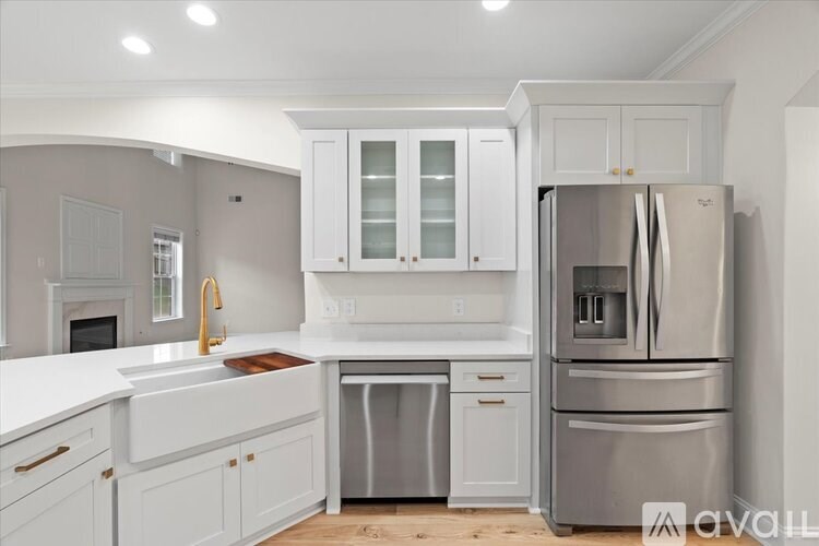 A modern kitchen with white cabinets and stainless steel appliances.