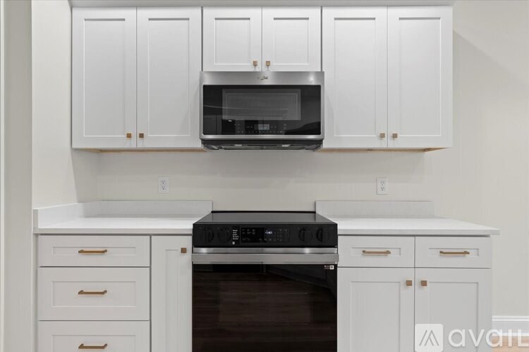 A kitchen with white cabinets and a black oven.