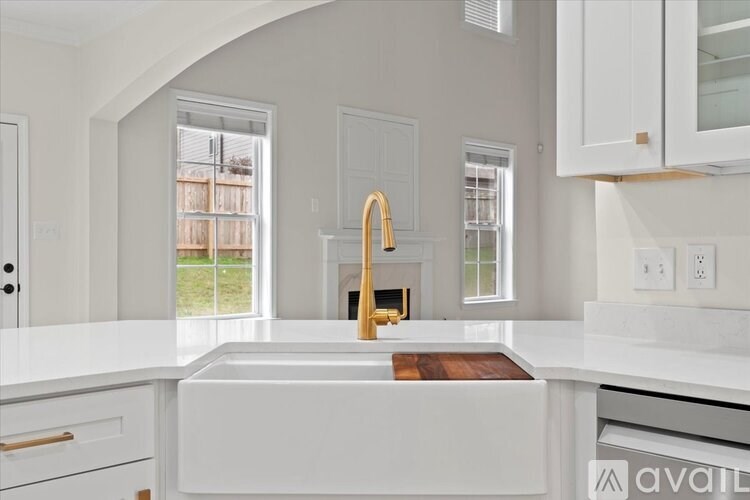 A kitchen with a white countertop and a wooden cutting board.