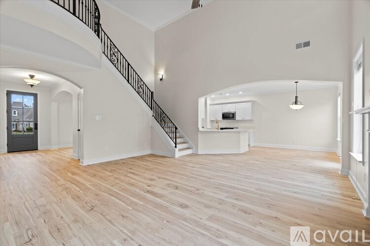A spacious living room with a staircase leading to the upper floor.
