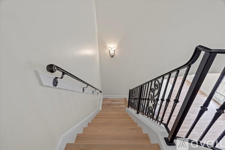 A staircase with a black railing and wooden steps.