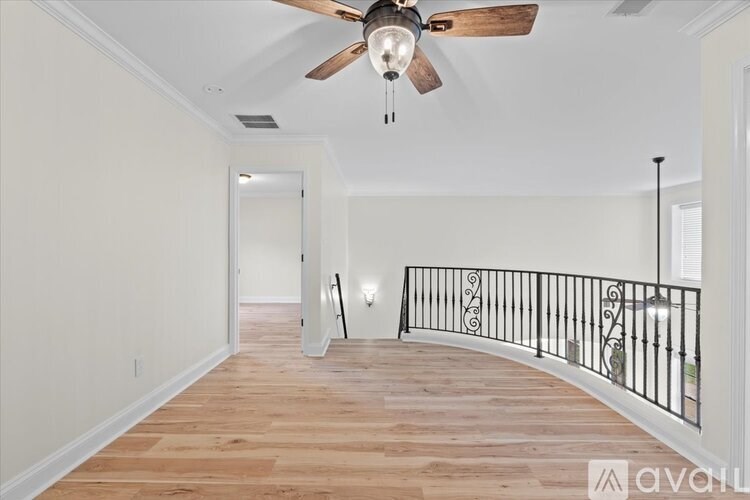 A room with a wooden floor and a ceiling fan.