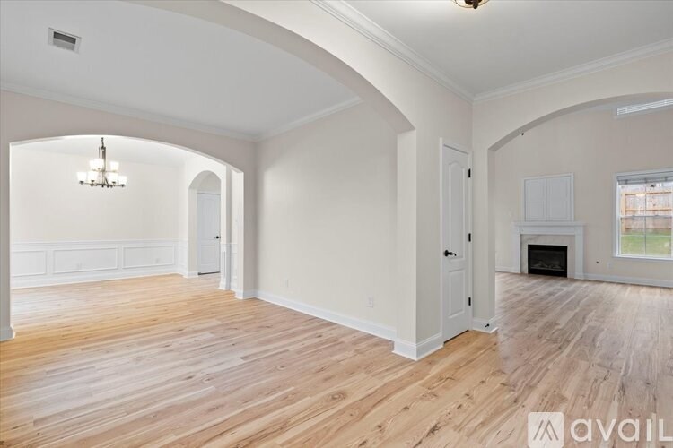 A spacious room with wooden floors and white walls.