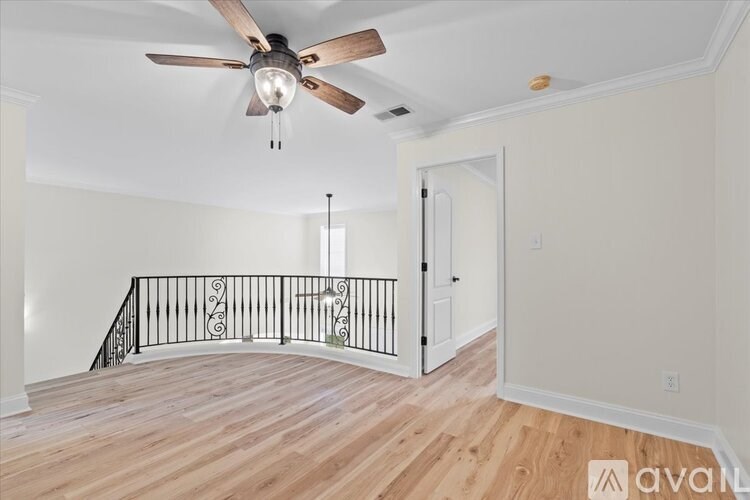 A room with a wooden floor and a ceiling fan.