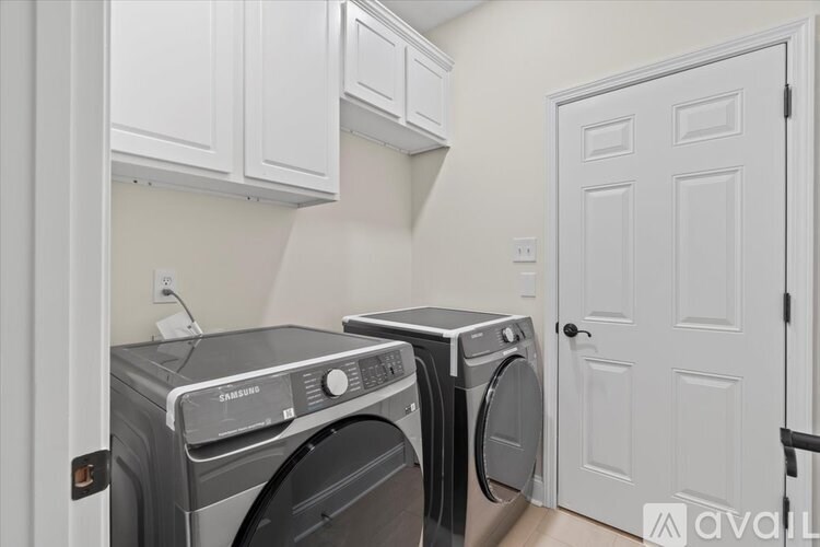 Two Samsung front load washing machines in a laundry room.