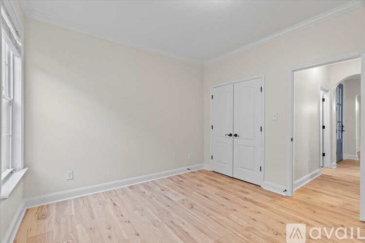 A room with wooden flooring and white walls.