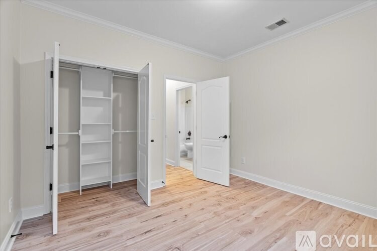 A room with a white door and a white closet with shelves.