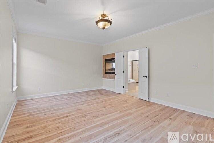 A room with wooden flooring and a mirror on the wall.
