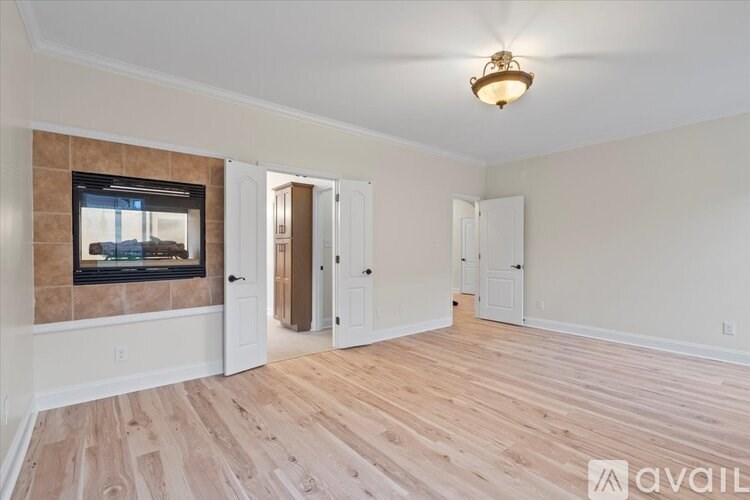A room with wooden flooring and a chandelier hanging from the ceiling.