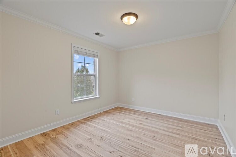 A room with wooden flooring and a window.