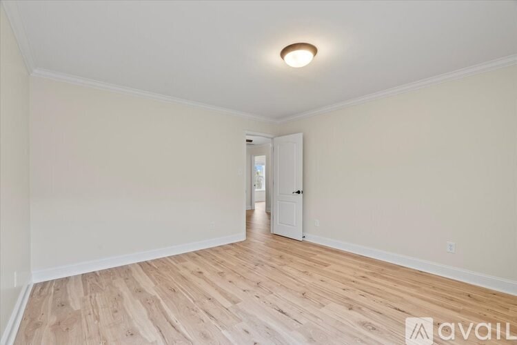 A room with wooden flooring and a white door.