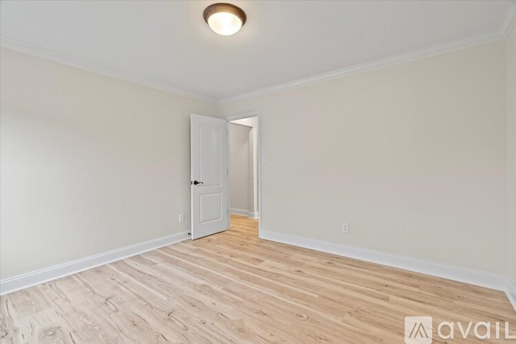 A room with a wooden floor and a white door.