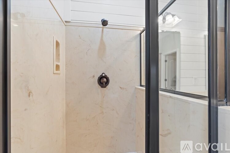 A bathroom with a shower and a glass door.