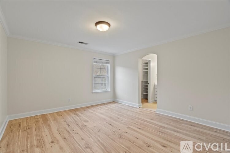 A room with wooden flooring and a white ceiling with a light fixture.