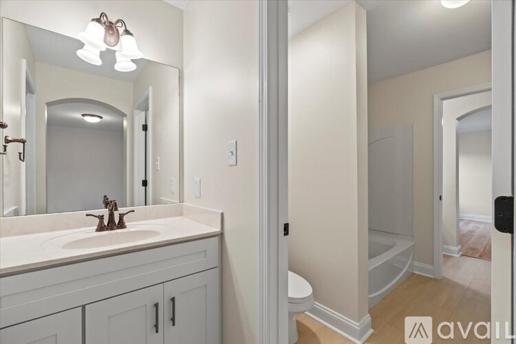A bathroom with a sink, mirror, and toilet.