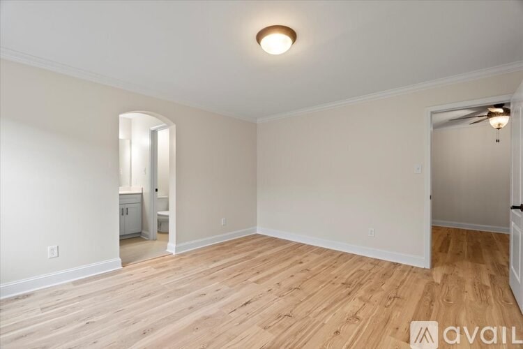 A room with wooden flooring and a ceiling fan.