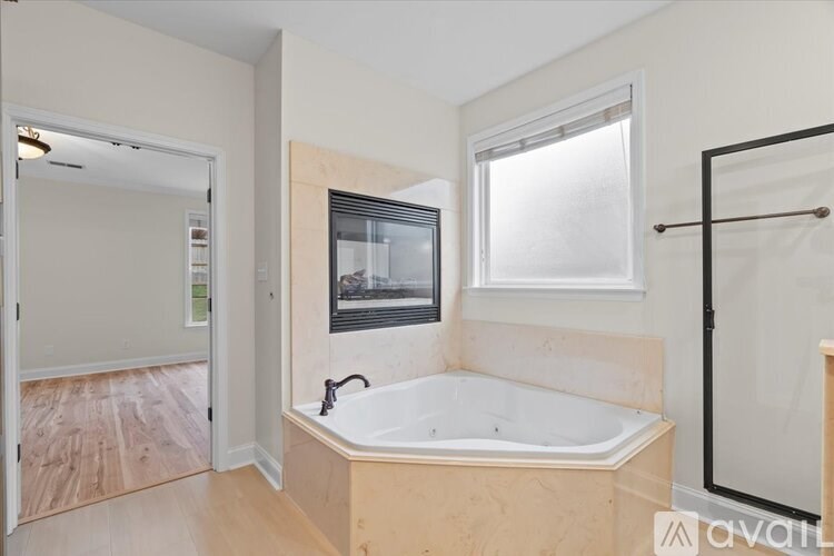 A bathroom with a tub and a window.