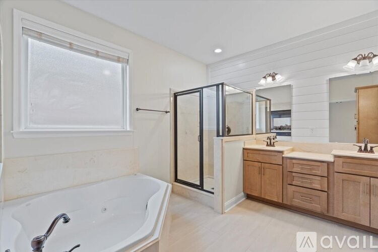 A bathroom with a tub, sink, and mirror.
