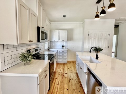 A kitchen with white cabinets and a white countertop.