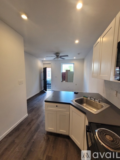 A kitchen with white cabinets and a black countertop.