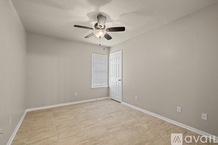 A room with a ceiling fan and a door.
