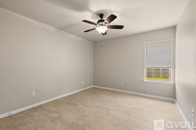 A room with a ceiling fan and a window.